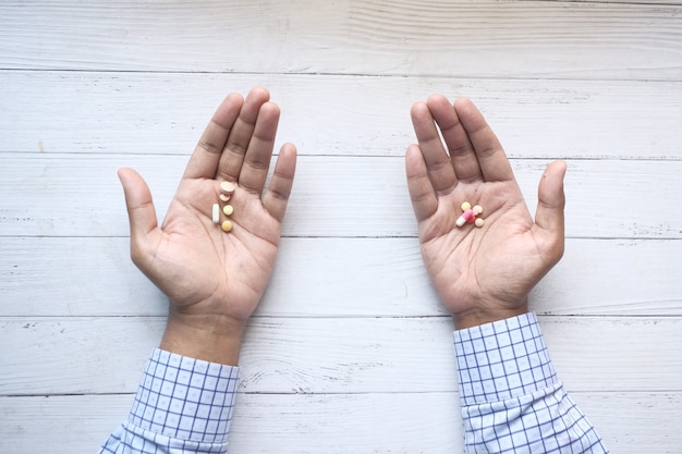 Top view of many medical pills on palm of hand