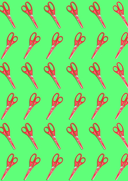 The top view of a many red colored plastic scissors on green background