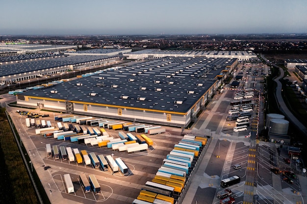 Top view of many trailers and containers near the logistics warehouse in the evening