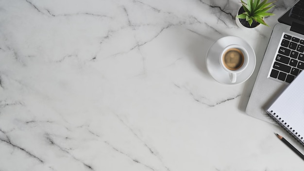 Top view marble texture workspace is surrounding by a laptop and various accessories