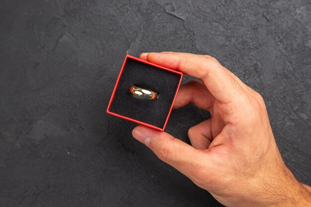 ボックスで結婚指輪を持っている平面図のプロポーズの概念の人の手