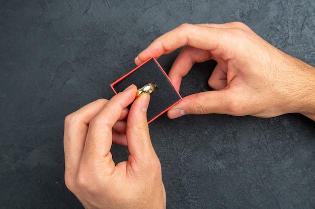 top view marriage proposal concept man hands holding wedding ring