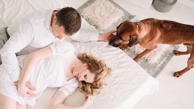 Вид сверху супружеская пара с домашним животным в спальне