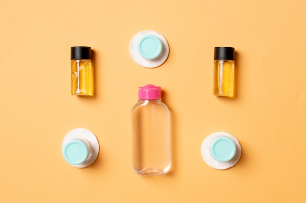 Top view of means for face care bottles and jars of tonic micellar cleansing water cream pads