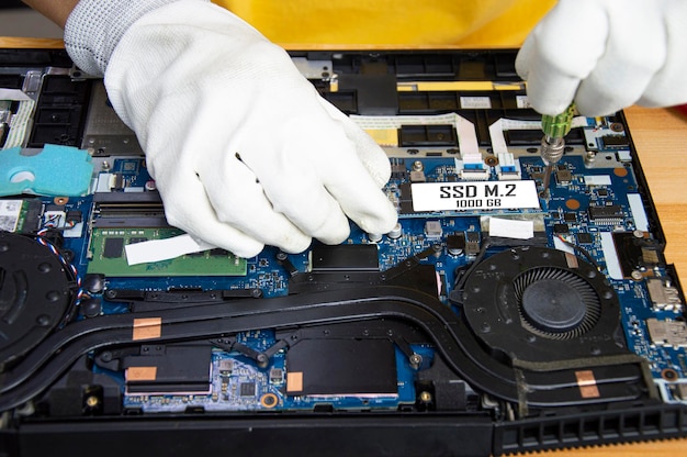 Top view of mechanic repairing computer installing M2 SSD