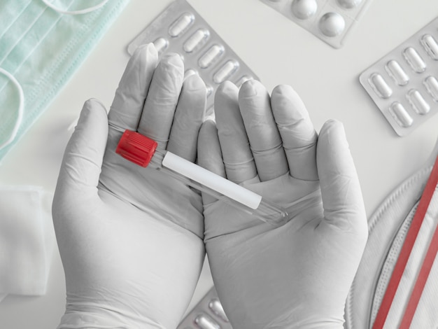 Photo top view of medical concept with syringe, medical mask, medicine and test tube on white table background