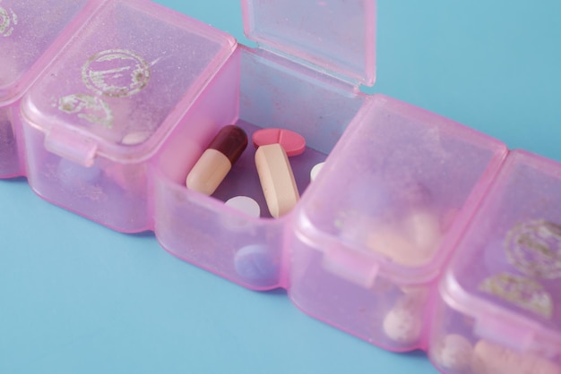 Top view of medical pill box on color background