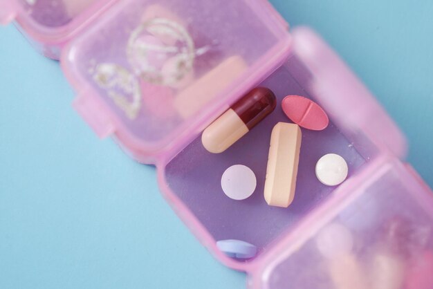 Top view of medical pills in a pill box on color background