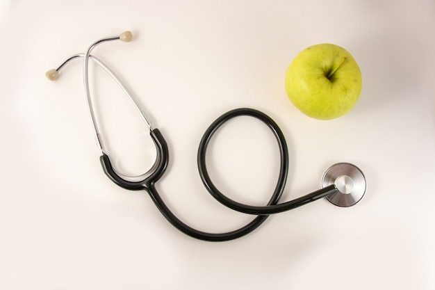 Top view medical stethoscope and an apple