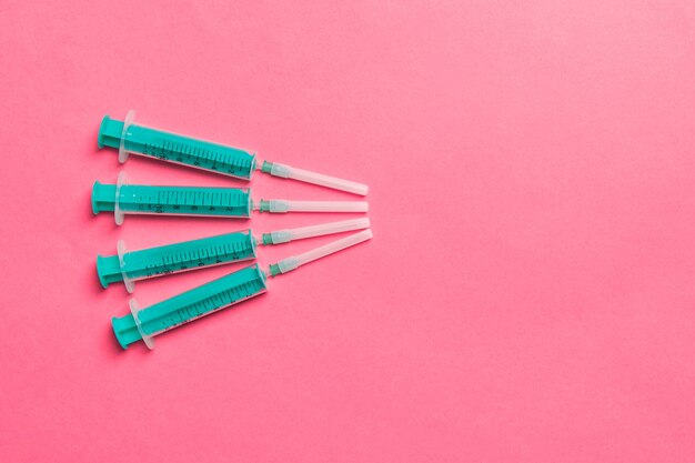 Top view of medical syringes on colorful background with copy space. Injection equipment concept.