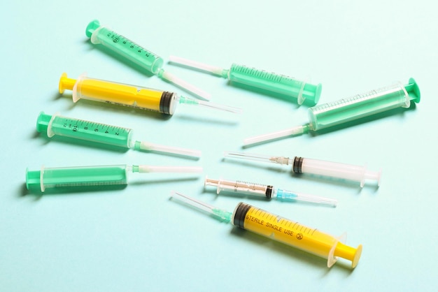 Top view of medical syringes with needles at blue background with copy space Injection treatment concept