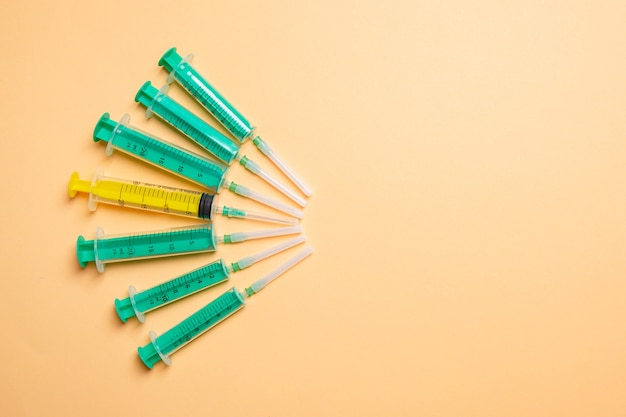 Top view of medical syringes with needles at orange