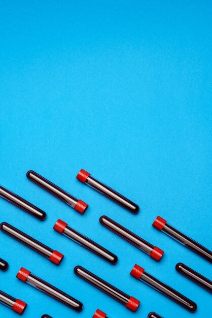 Top view of medicine test tubes with blood samples over blue background.