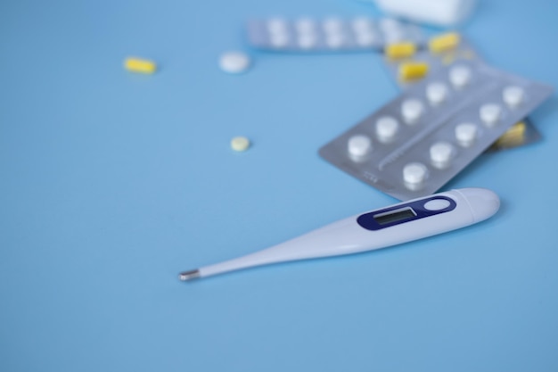 Top view of medicines thermometer on a blue blue background He was lying flat