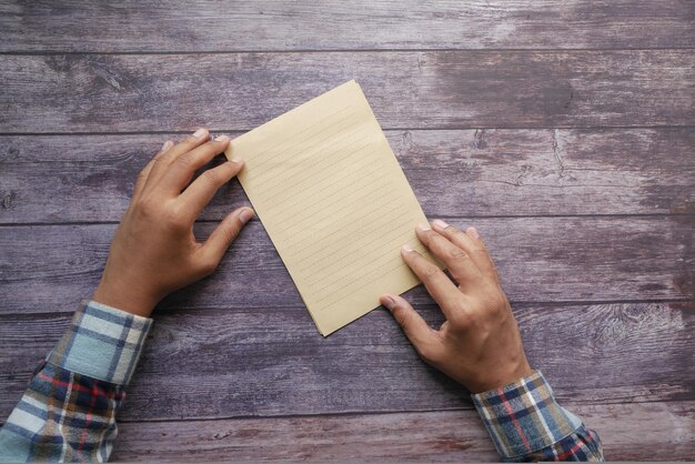 Top view of mens hand on blank paper on table