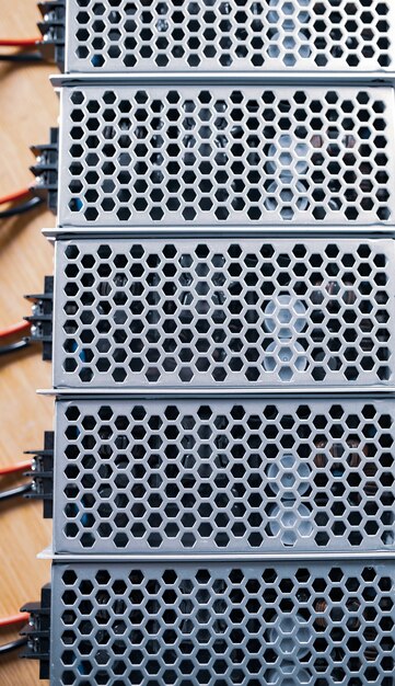 Top view of the metal mesh power supply of the microcircuit are\
on a wooden table at the production of high-tech computers. concept\
of high technology and office equipment