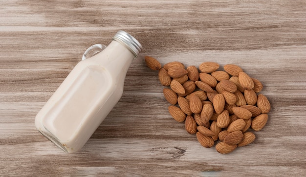 Photo top view of milk bottle and almonds