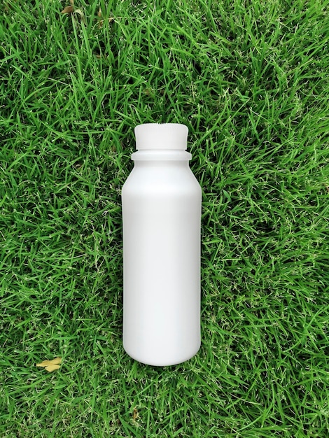 Вид сверху на бутылку молока на траве