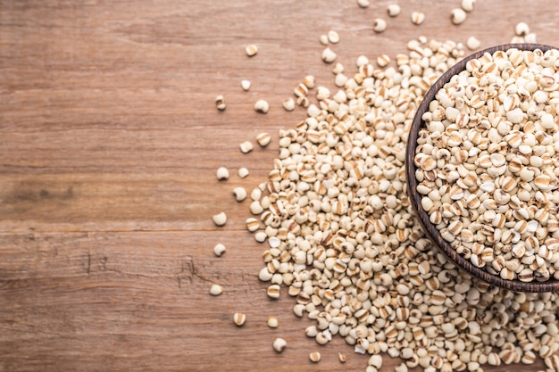 Top view millet rice or millet grains in wooden bowl put on wooden table background