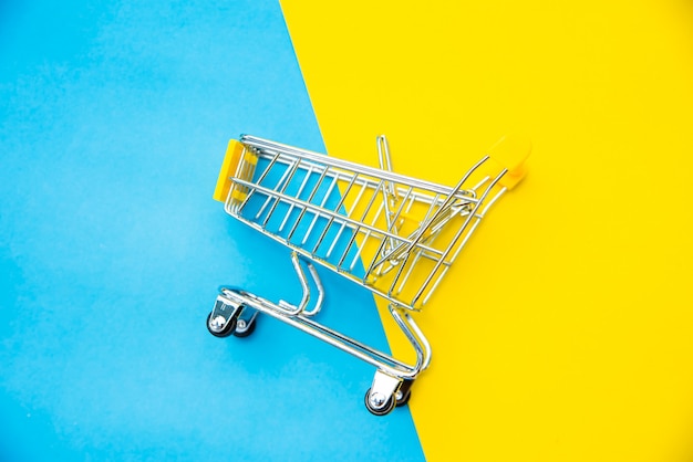 Top view for mini shopping cart on a colorful background.