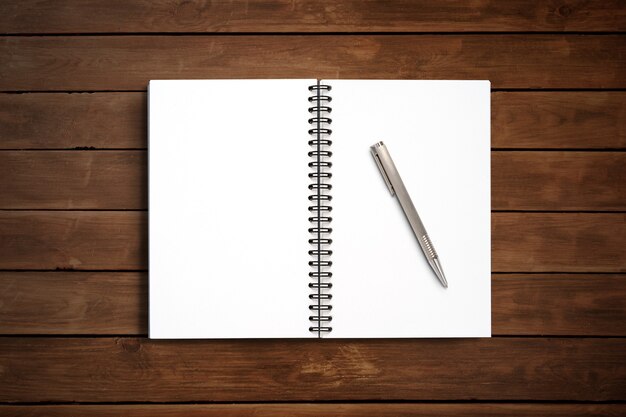 Top view Minimal design of open Notebook with pen on wooden background.