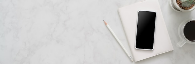 Top view of minimal home office with smartphone on marble table