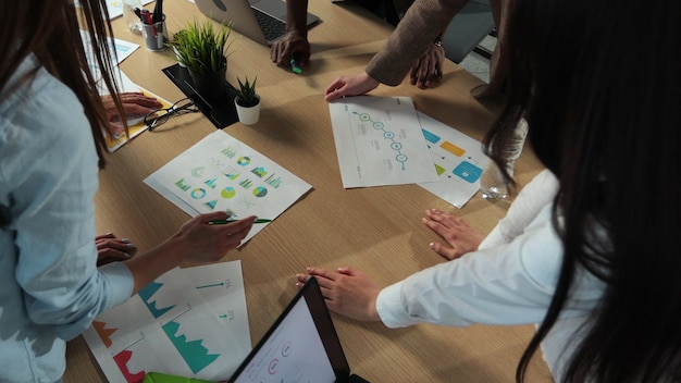 재무 데이터와 그래프를 보여주는 디지털 태블릿을 사용하여 창의적인 회의를 계획하는 회사를 시작하는 사람들 사무실 소규모 비즈니스의 상위 뷰 혼합 인종 그룹