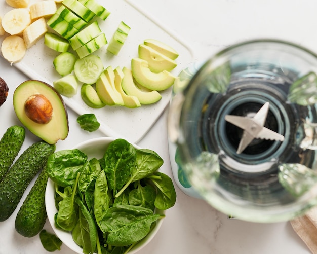 写真 トップビュー フルーツと野菜の食材をテーブルと空のブレンダーで混ぜる