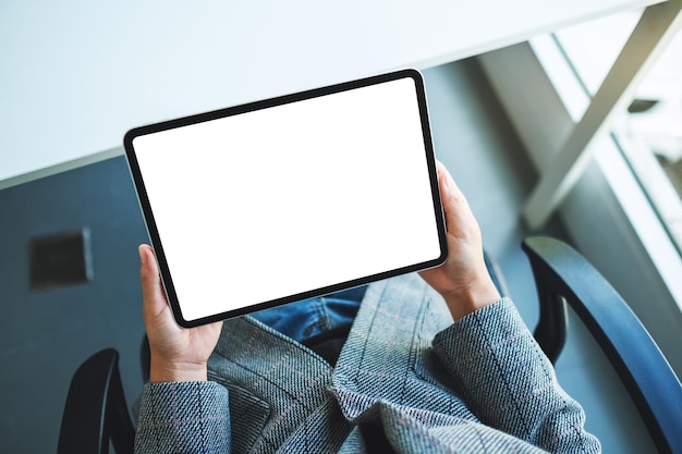 Top view mockup image of a business woman holding black tablet pc with blank white desktop screen