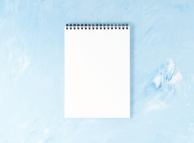 Top view of modern bright blue office desktop  notepad. , empty