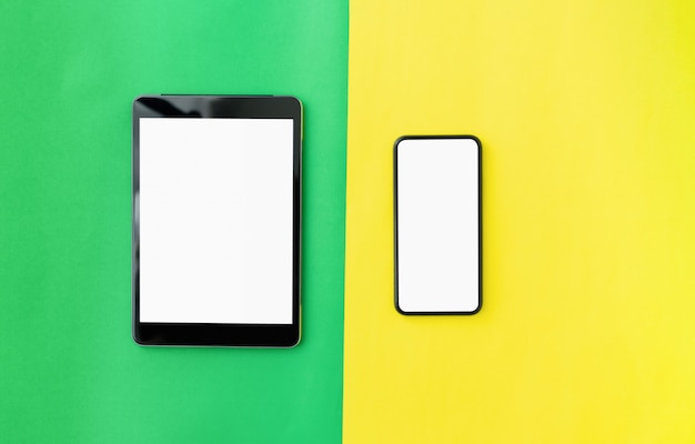 Photo top view of modern digital tablet and smartphone on green with yellow color