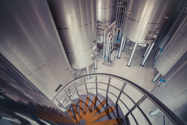 Photo top view modern milk cellar with stainless steel tanks with in stairway