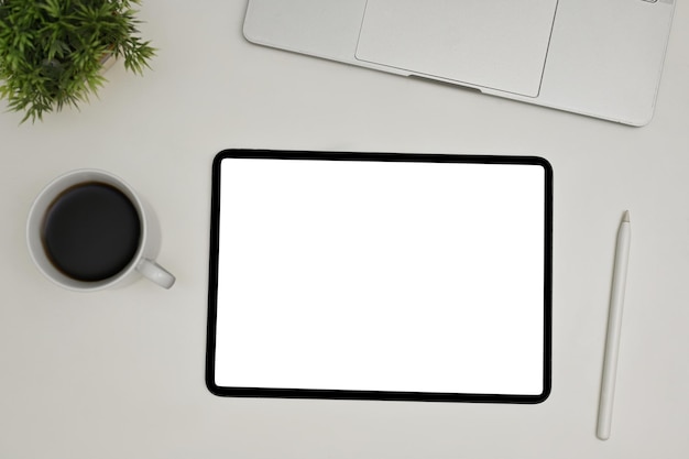 Top view of a modern workspace with digital tablet white screen mockup stylus pen laptop