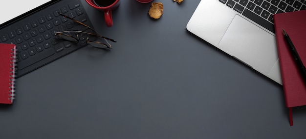 Top view of modern workspace with laptop computer and tablet with office supplies