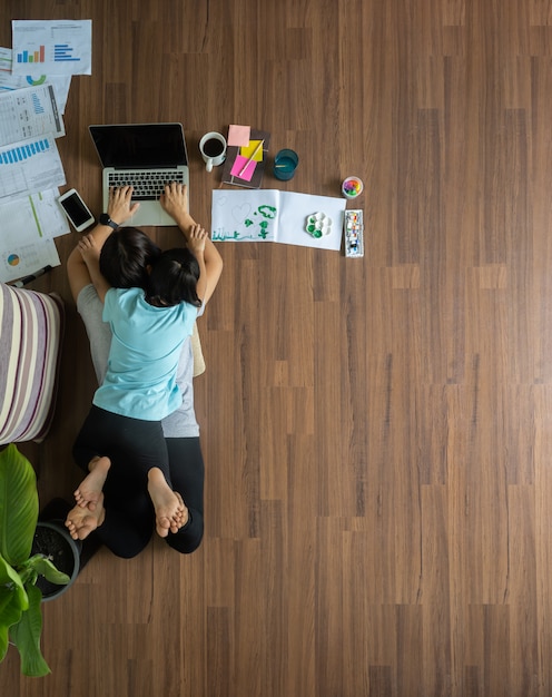 Photo top view mom and daughter work from home