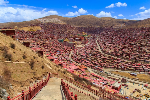 日の出日青い空、四川省、中国のLarung gar（仏教学院）でトップビュー修道院