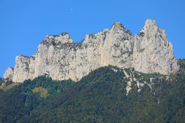 Photo top view of mountain peaks with blue sky and parachutes in  summer