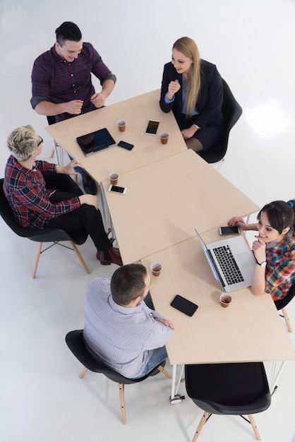 Вид сверху на многоэтническую группу стартапов-бизнесменов на мозговом штурме в современном светлом офисном интерьере