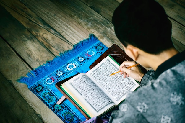 Top view of Muslim man reading Quran during ramadan