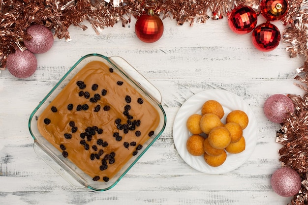 Top of view of natilla and bunuelos traditional christmas food in Colombia over old white background Traditional christmas food