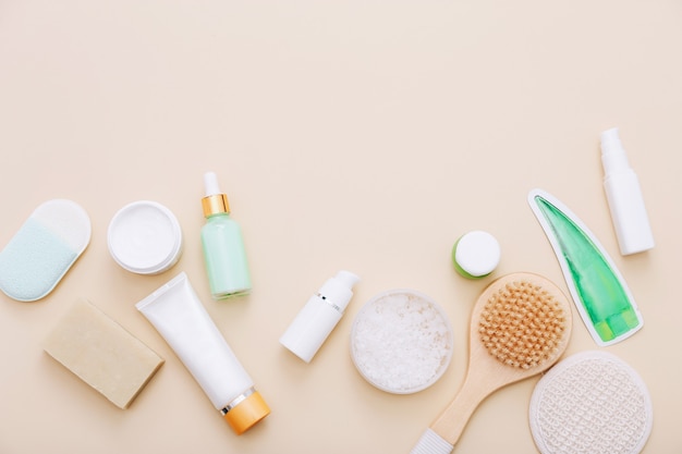 Vista dall'alto di prodotti cosmetici per la cura della pelle e spa naturali su beige