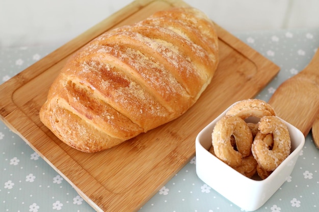 Top view naturally fermented bread on a wooden board and sugar donuts selective focus