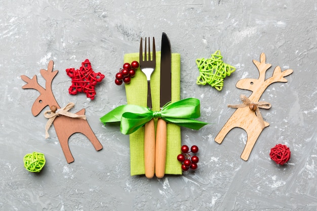 Top view of new year utensils on napkin with holiday decorations and reindeer on cement , 