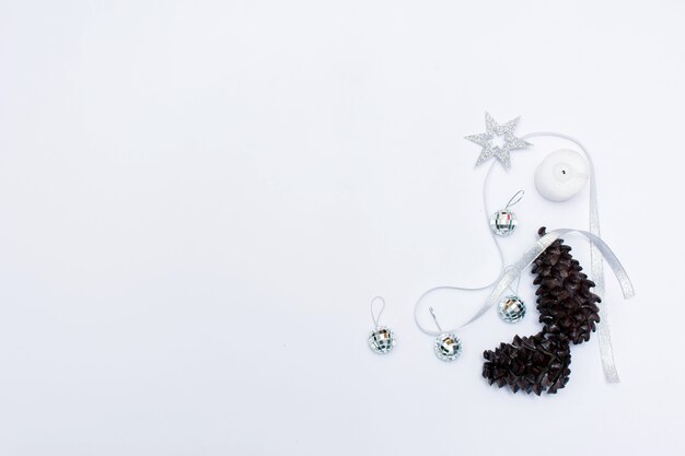 Вид сверху на красивый рождественский подарок, завернутый в белую подарочную бумагу, елочные украшения на