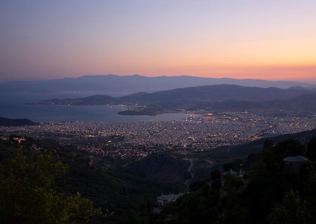 Top view of the night city with Volos lighting in Greece at sunset