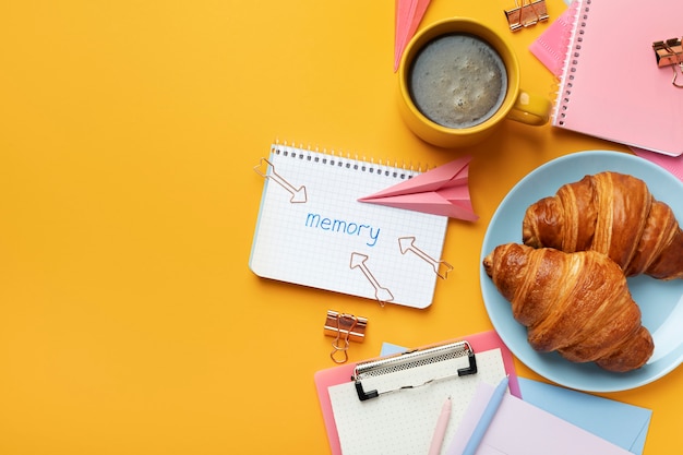 Top view notebook and croissants arrangement