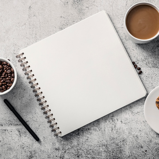 Photo top view of notebook with coffee cup and pen