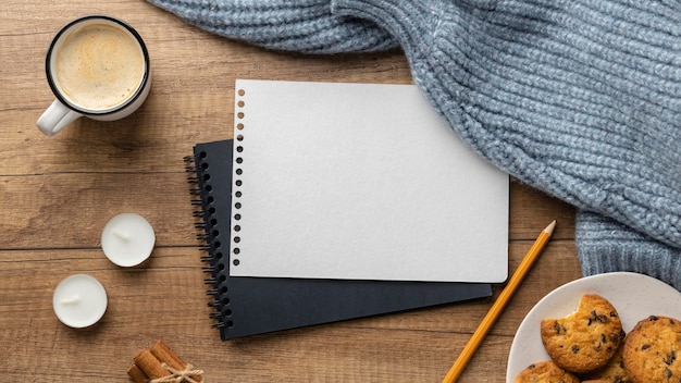 Top view of notebooks with cup of coffee and sweaters