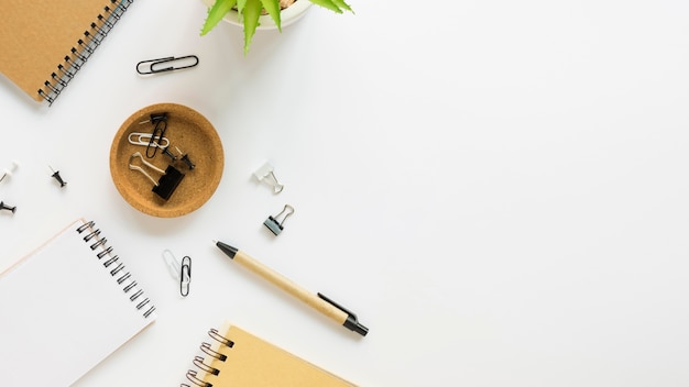 Top view of notebooks with office stationery and plant