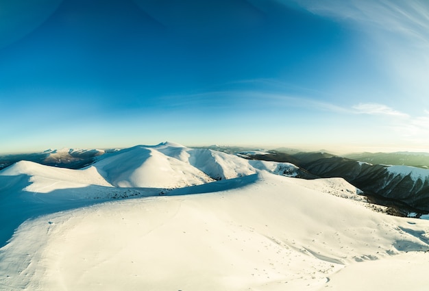 晴れた冬の凍るような夜に山に位置するスキートレイルのあるスキースロープの美しい魅惑的な景色の上面図